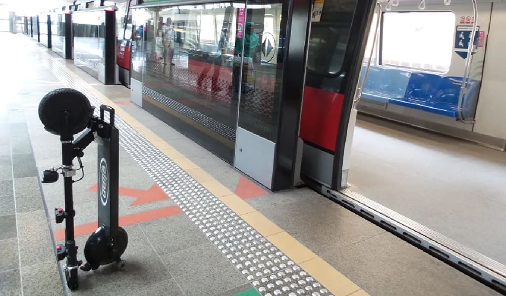 Electric scooter commuting next to public transportation train