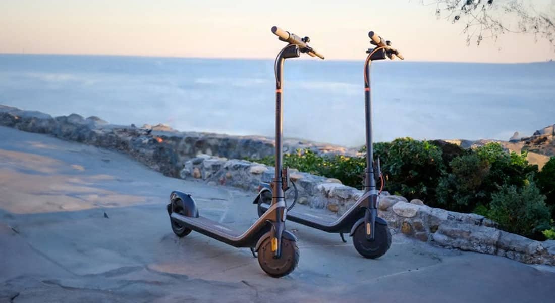 The E2 and E2+ standing upright on the road past the ocean and beach