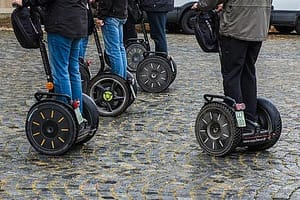 Multiple people riding segways on cobblestone